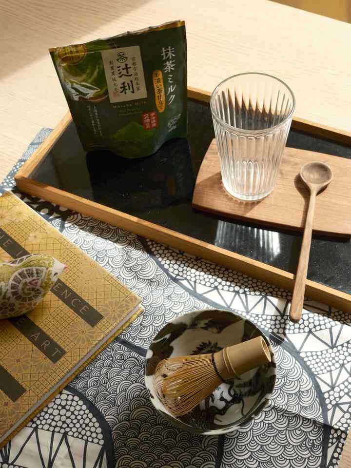 Natural tone table setting with tea utensils and glass on a cozy home cafe space
