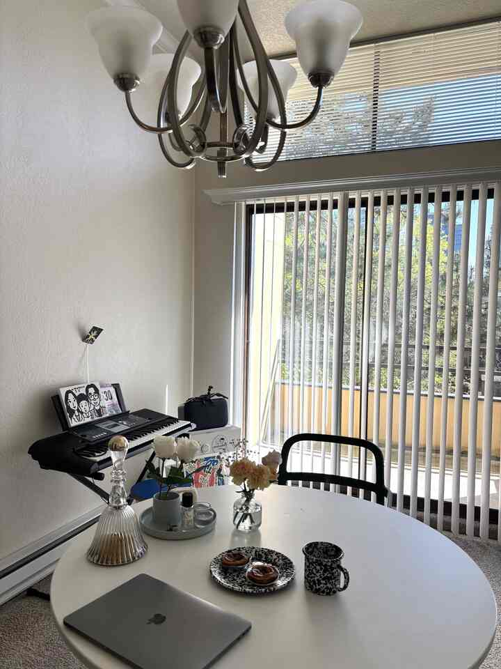 White and black toned dining room with round table and blinds creating bright, clean home cafe ambiance