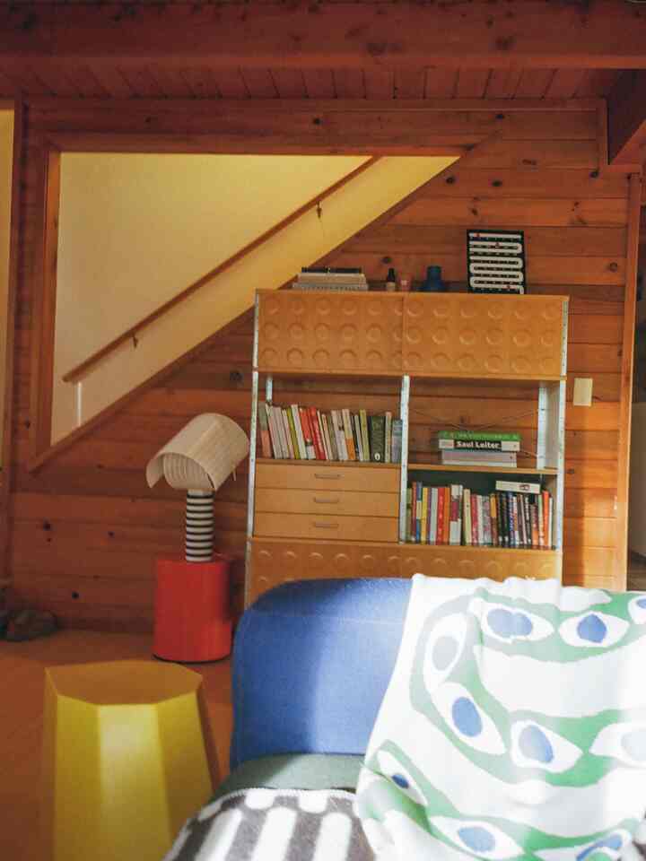 Warm wood tone living room featuring a blue sofa, retro furniture, and a cozy Nordic-inspired atmosphere