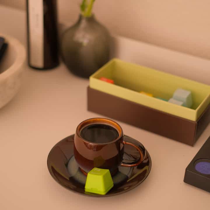 Brown-toned kitchen space featuring a small espresso cup with bright box accents creating a cozy home cafe vibe