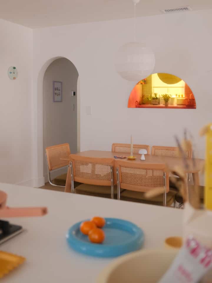 Soft white and natural brown toned dining room featuring a wooden dining table and chairs with a cozy atmosphere