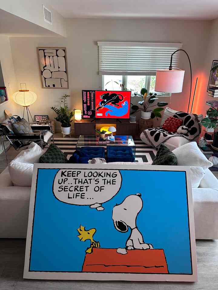 Bright toned living room featuring white sofa, floor lamp, TV stand, and plants in a Nordic modern style space