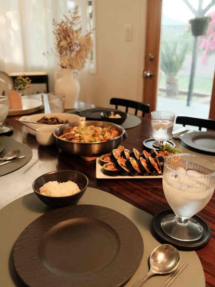 Natural-toned dining room featuring a wood tone table set with various plates and bowls for a cozy atmosphere