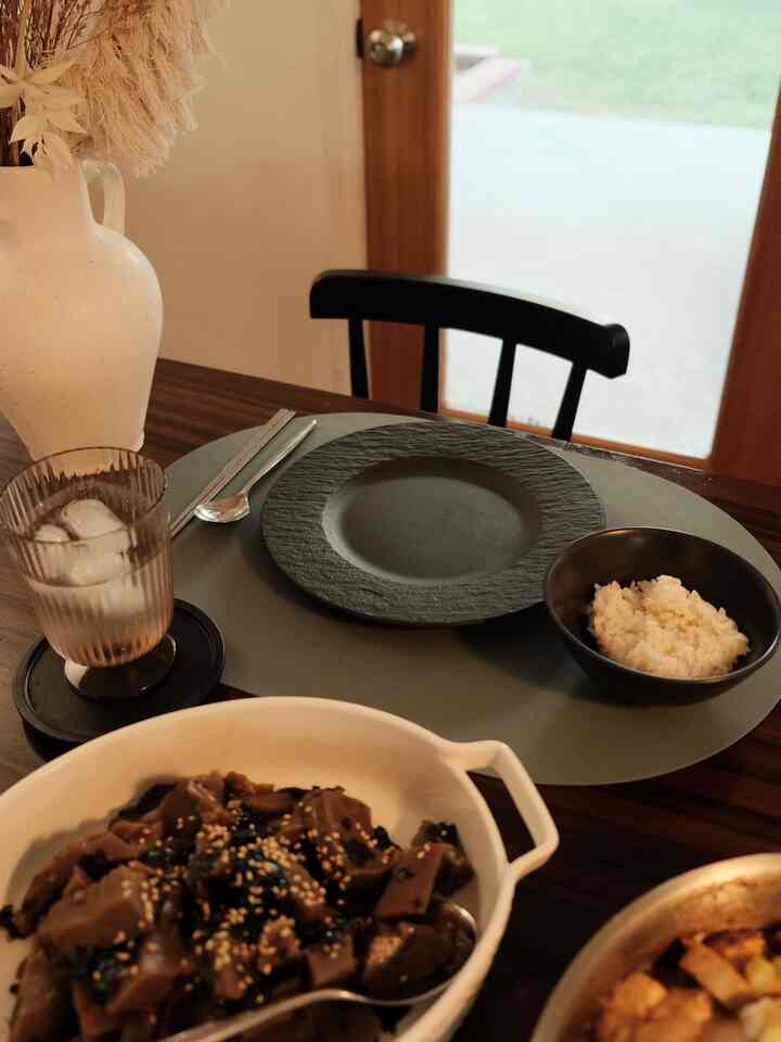 Natural toned dining room with wooden table and black chairs, calm atmosphere for home dining experience