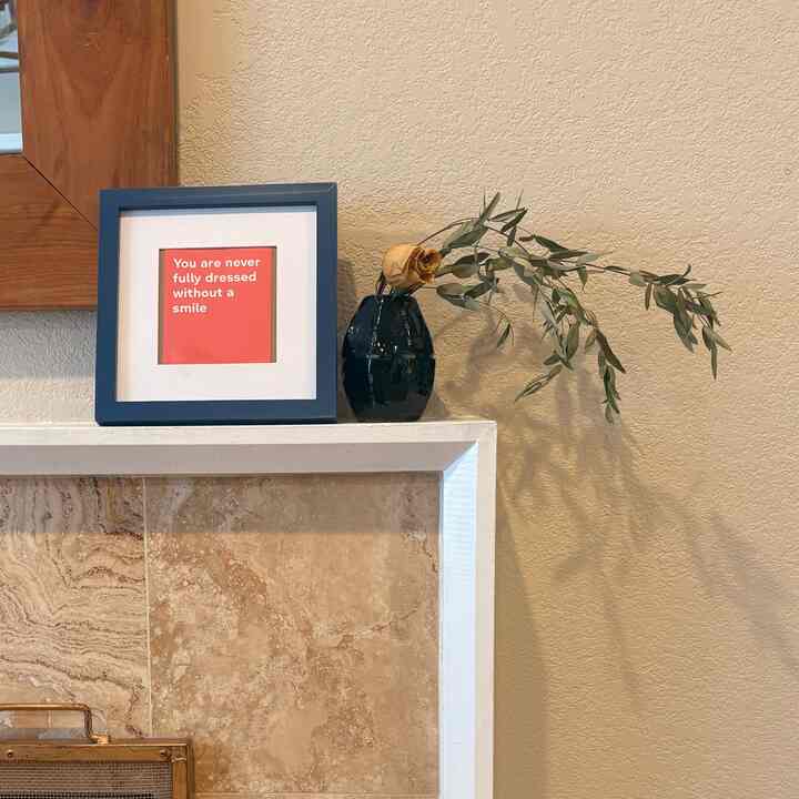 Beige-toned wall living room cozy corner featuring navy picture frame and dried flower decoration
