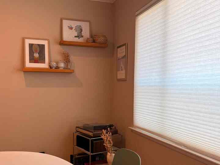 Warm brown tones and white dining room featuring wooden wall shelves and a vintage turntable with a soft, cozy atmosphere