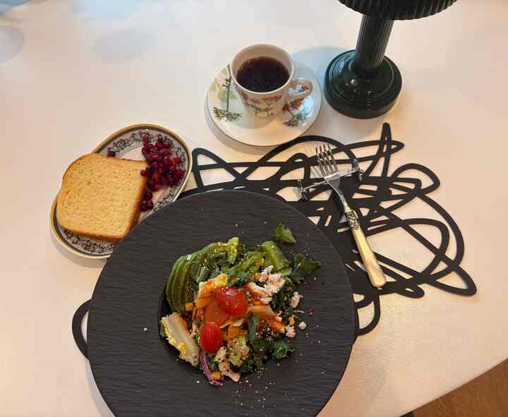 White table featuring a modern home cafe setting with black plate and coffee cup serving a healthy breakfast