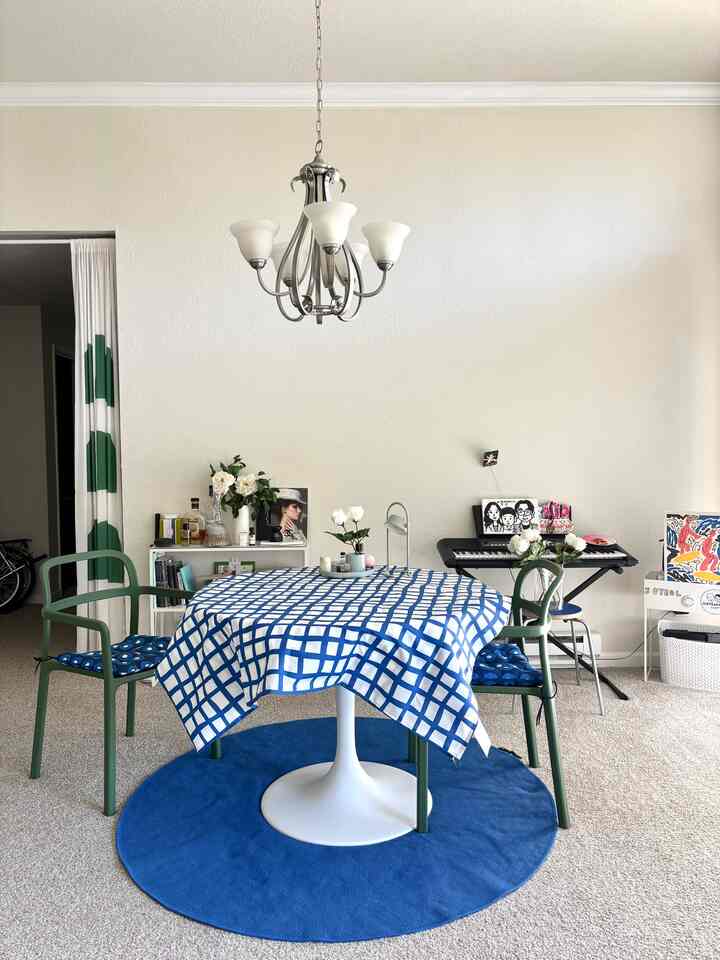 Modern dining room featuring white walls and blue-toned dining table with natural, cozy atmosphere