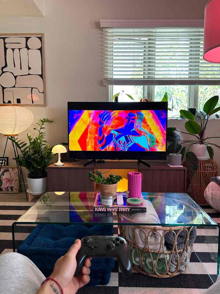 White and natural-toned living room featuring TV and game controller creating a game room vibe