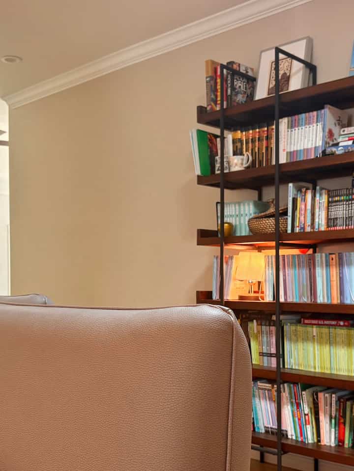 Warm natural color walls and wood-tone bookshelf in a cozy Nordic style living room space
