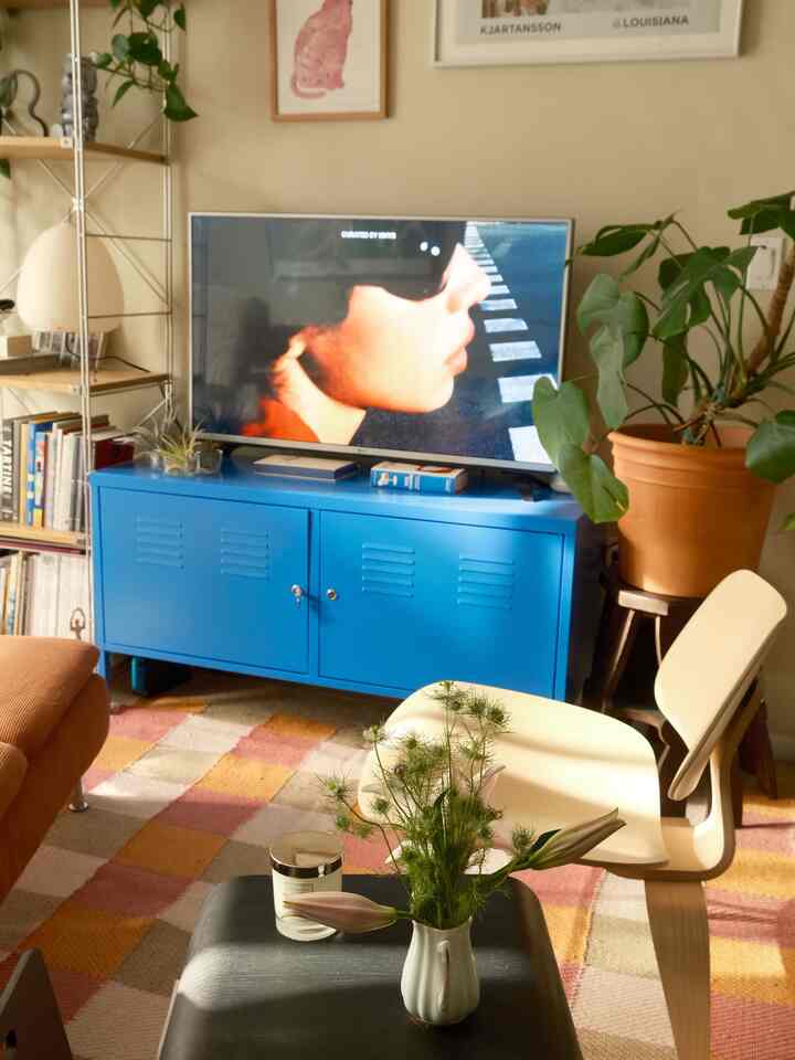 Cozy living room featuring a bright blue TV cabinet and mid-century modern chair