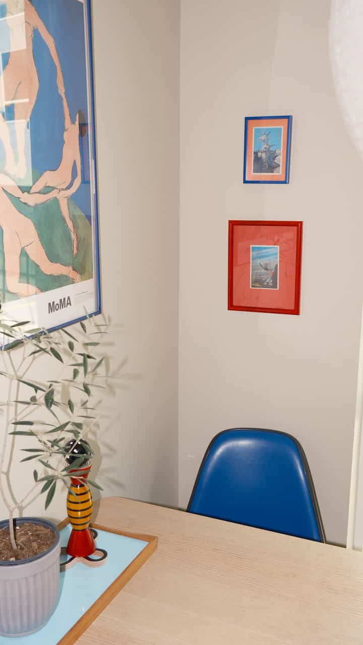 White walls and Nordic style dining table featuring a blue dining chair and potted plant in a simple dining room