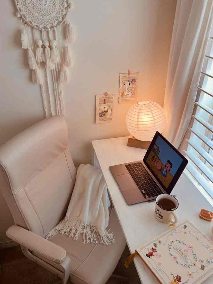 White and natural toned small home office featuring a rotating chair and round paper lamp creating a cozy atmosphere