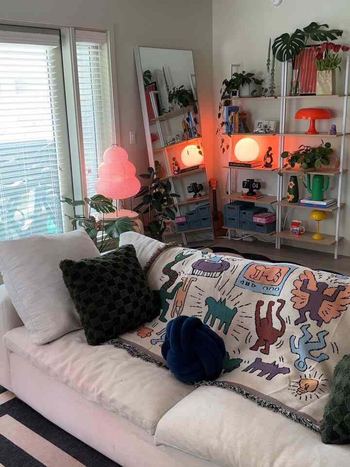 Natural-toned living room featuring a large beige sofa, various floor lamps, and plants creating a cozy and relaxed atmosphere
