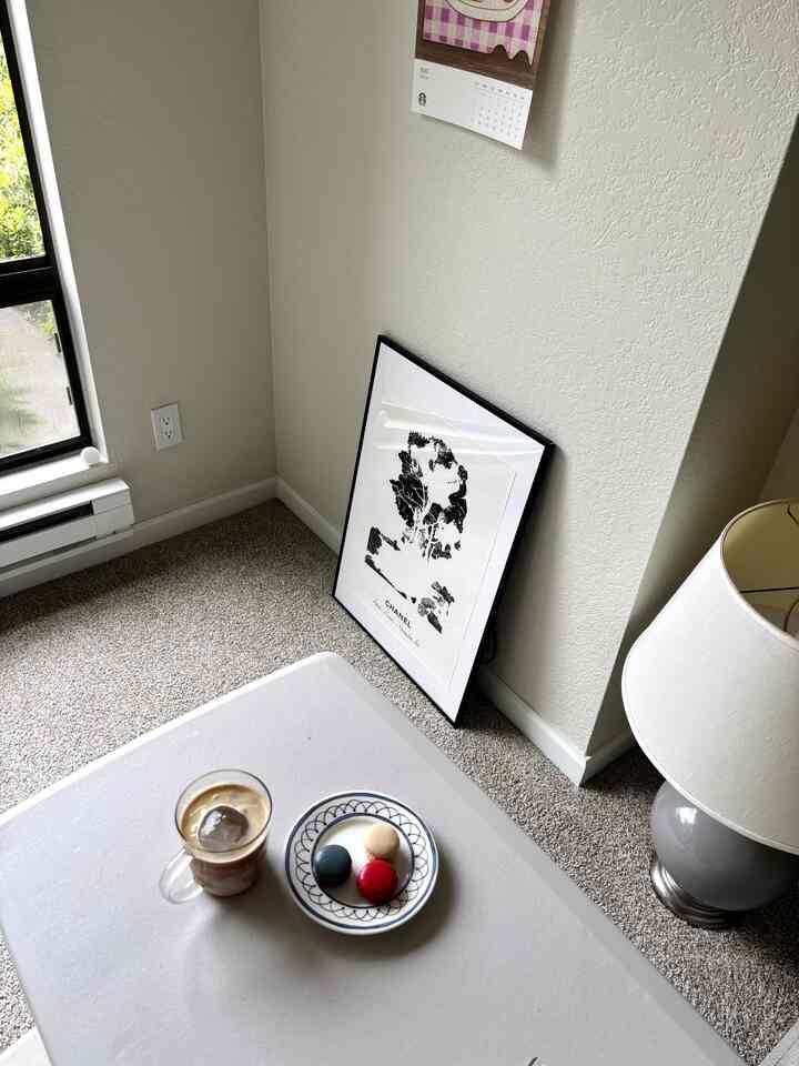 White and gray toned corner space featuring table with coffee and dessert plate, creating a cozy home cafe atmosphere