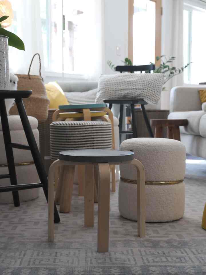 White and navy toned living room featuring various stools and ottomans in a cozy arrangement