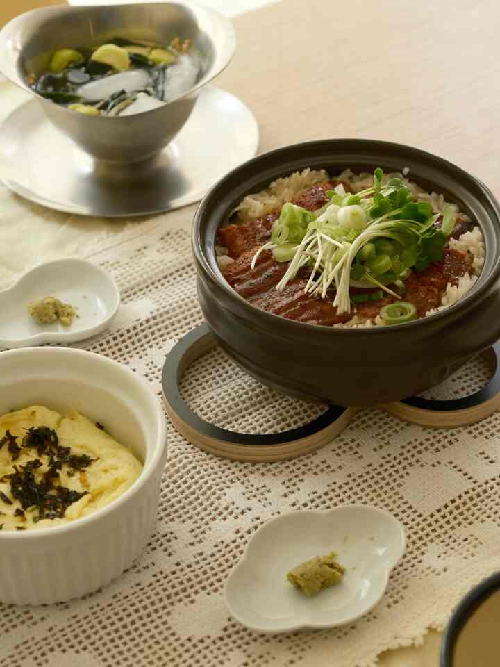 Natural-toned dining table featuring pot rice and side dishes in a cozy kitchen table setting