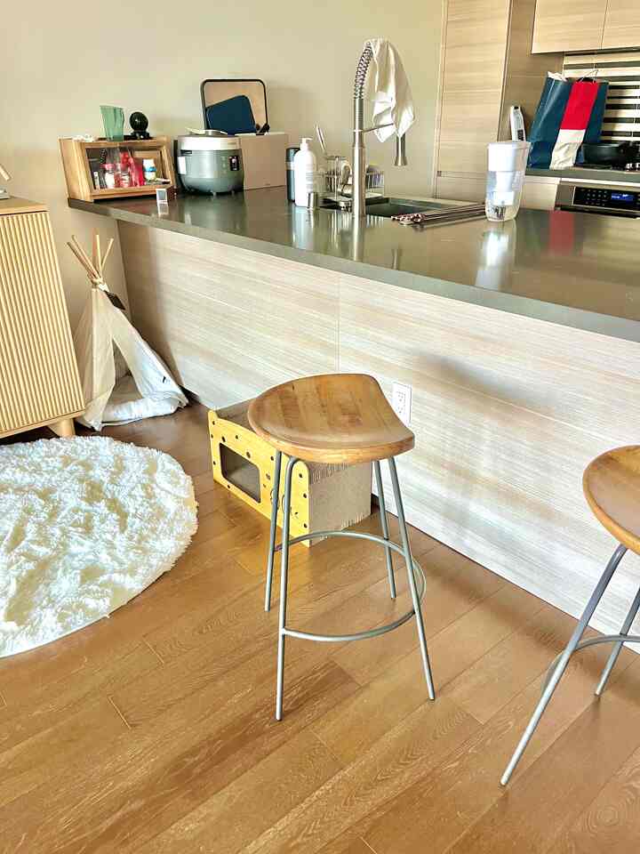 Natural wood tone and white round rug in kitchen island with bar stools creating a cozy home cafe space