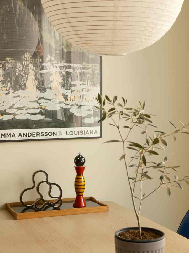 Natural wood tone dining room with white background, featuring a tray and plant for a simple, Nordic-inspired atmosphere