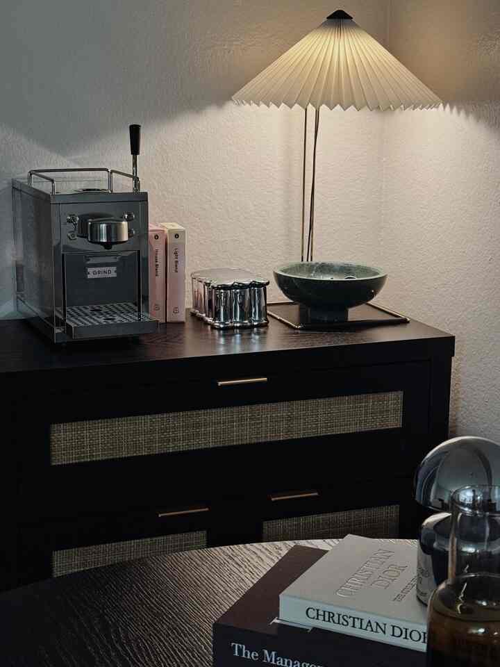 Cozy small apartment dining room in black and white tones, featuring a modern table lamp and home cafe setup