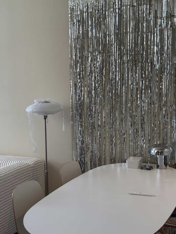 Silver and white toned dining room featuring a table lamp and floor lamp with a modern atmosphere