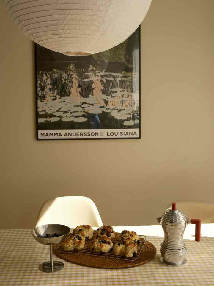 Yellow gingham tablecloth in a kitchen space featuring blueberry scones and a shiny aluminum coffee pot for a cozy home party setting