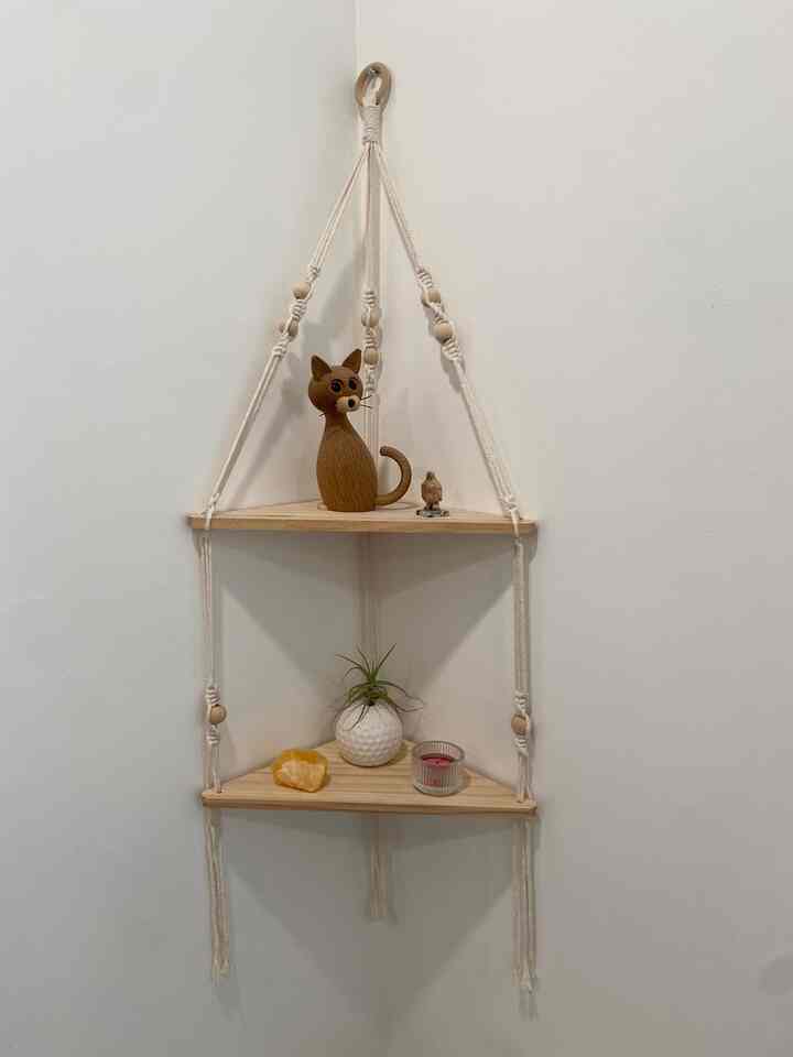 A hanging corner shelf with wooden figurines, a small plant, and simple decorative accents. #restroom 