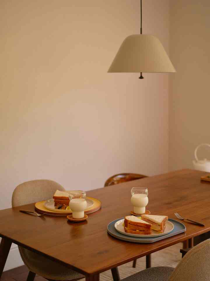 Beige-toned dining room featuring a wood tone dining table set for two with a cozy atmosphere