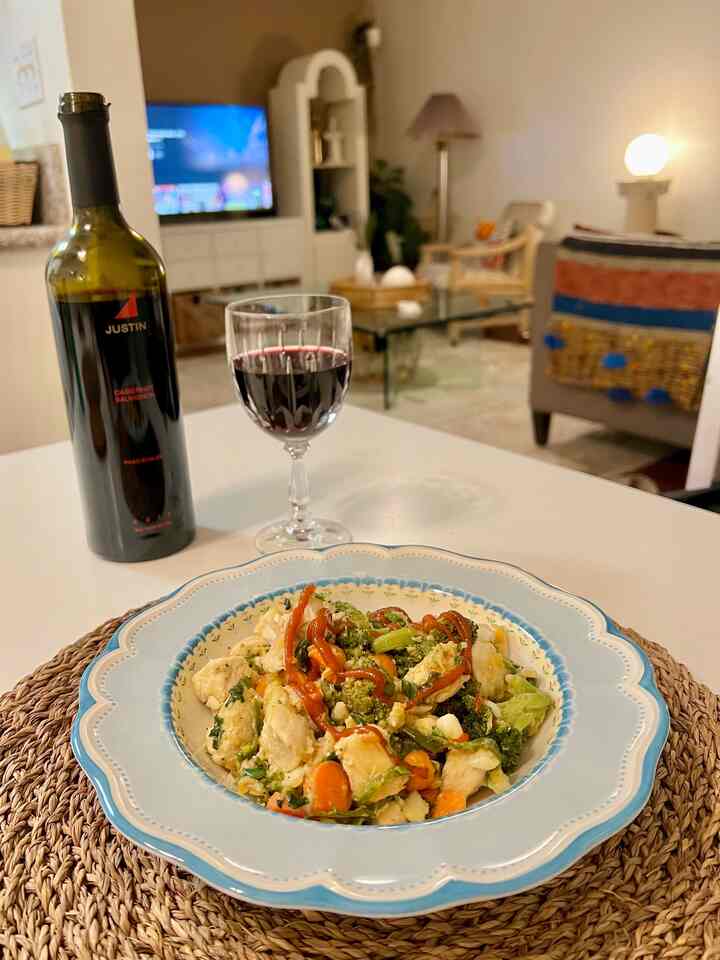 Natural-toned dining space featuring a wine glass and a plate on a placemat, creating a cozy home party vibe