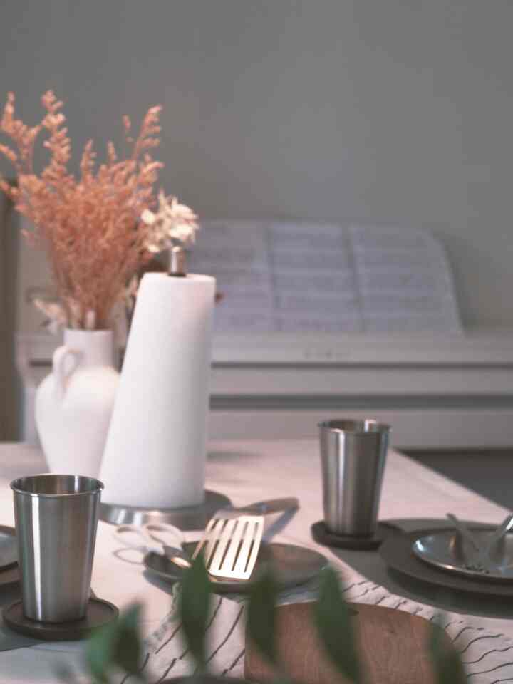 A Nordic-toned home bar space featuring Mid-Century Modern stainless steel tableware and cups on a white tablecloth for a home party