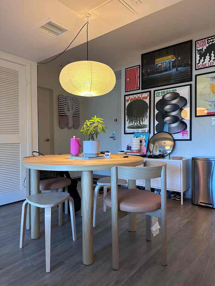 Wood tone and gray flooring dining room featuring a round dining table, chairs, and pendant lighting creating a cozy atmosphere