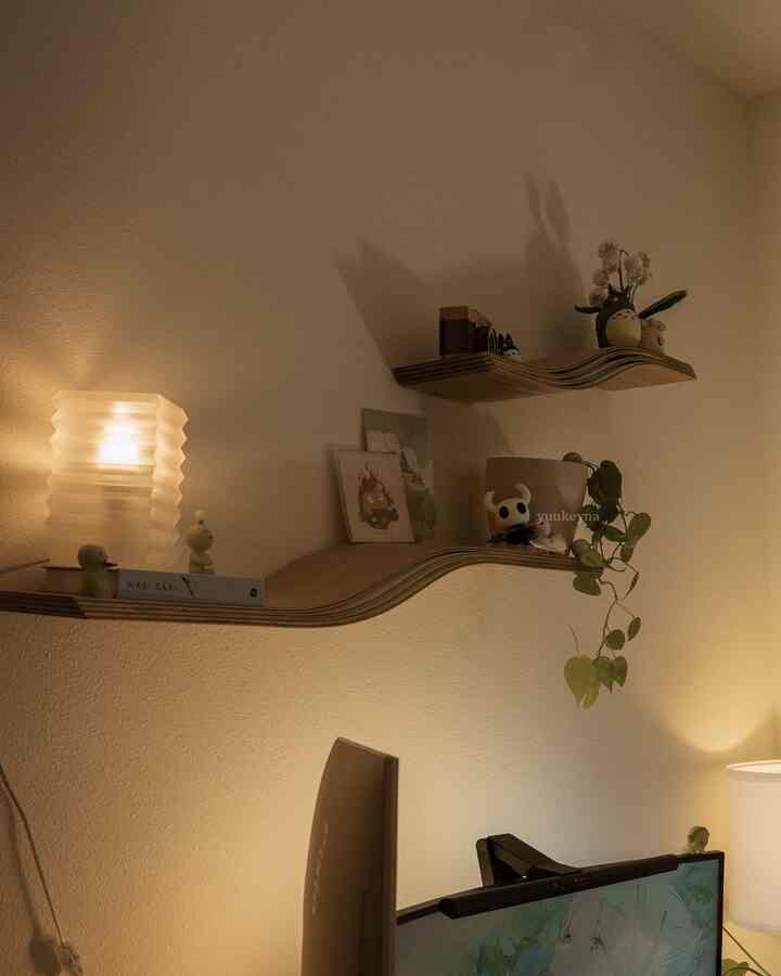 Warm wood tone home office with beige walls, featuring wavy shelves decorated with Ghibli character objets creating a cozy atmosphere
