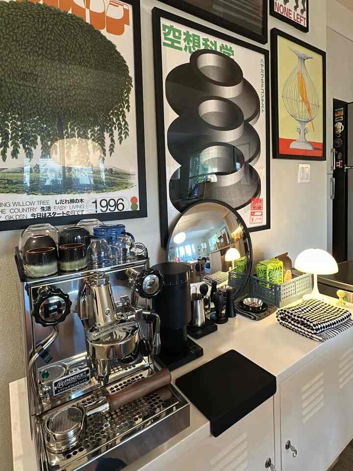 Modern home cafe kitchen in white and black tones featuring Rocket espresso machine and framed art