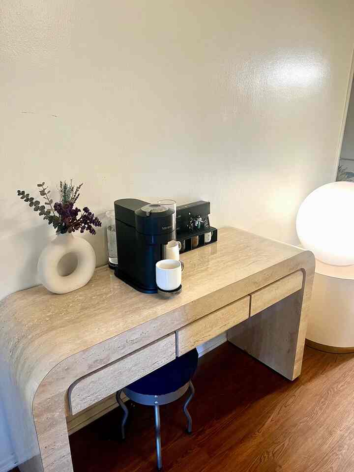 A beige-toned console table featuring a Nespresso coffee machine and vase creating a natural home cafe corner