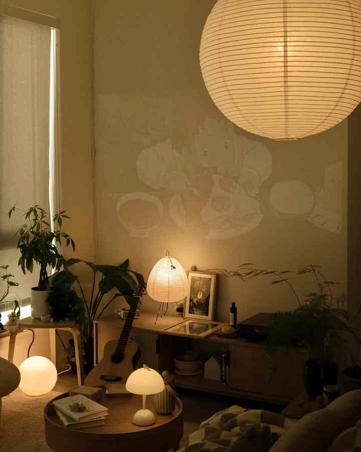 Warm natural toned living room featuring paper lamps and plants with a cozy remote work ambiance