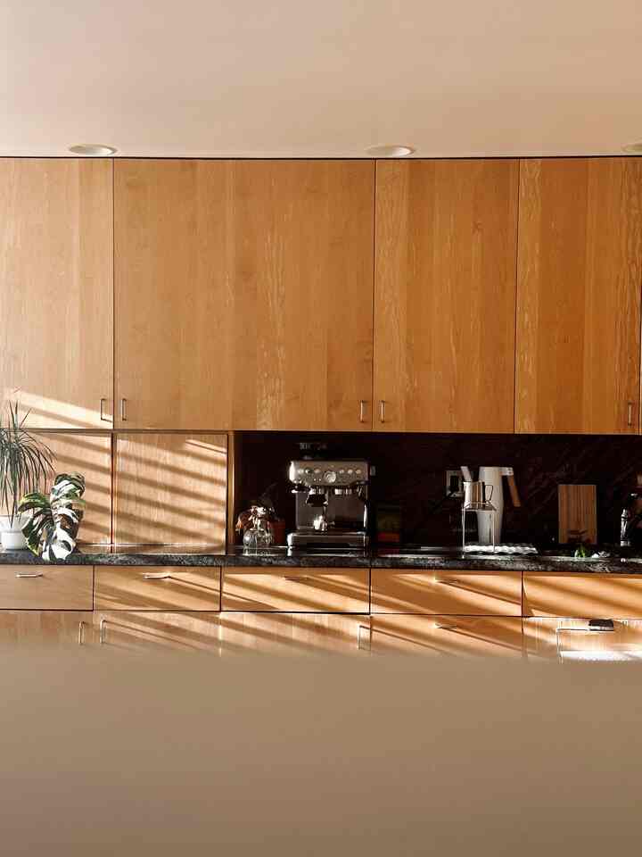 Warm wood tone kitchen space featuring a coffee machine and plants creating a cozy home cafe atmosphere