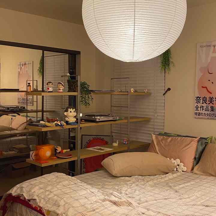 Beige and natural tone bedroom featuring a large paper lamp and open shelves, creating a cozy and comfortable ambiance