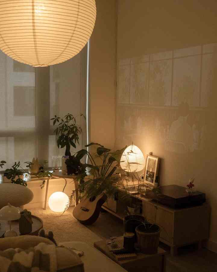 Bright beige-toned living room featuring wooden furniture and multiple plants with a warm, cozy atmosphere