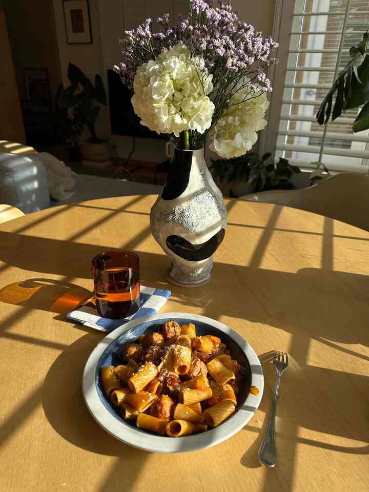 Warm natural tone living room dining table featuring a vase and vintage ceramic plate in a cozy home cafe setting