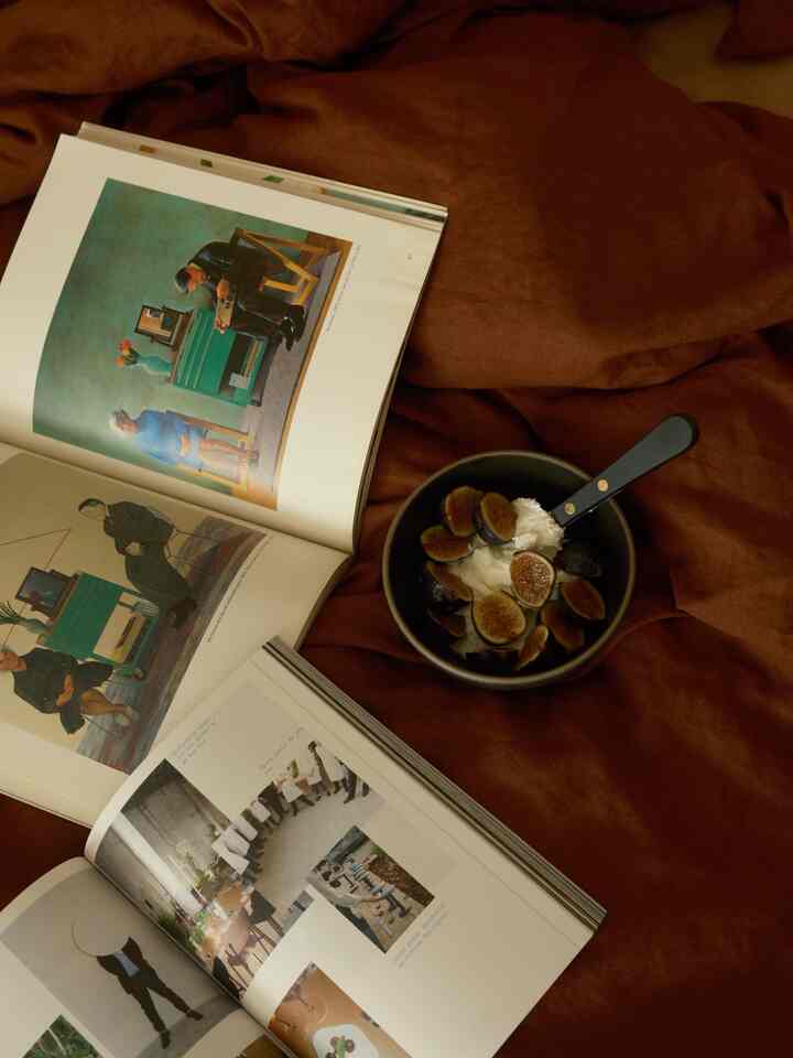 Warm brown-toned background featuring a black ceramic bowl with yogurt and figs in a cozy home cafe style setting