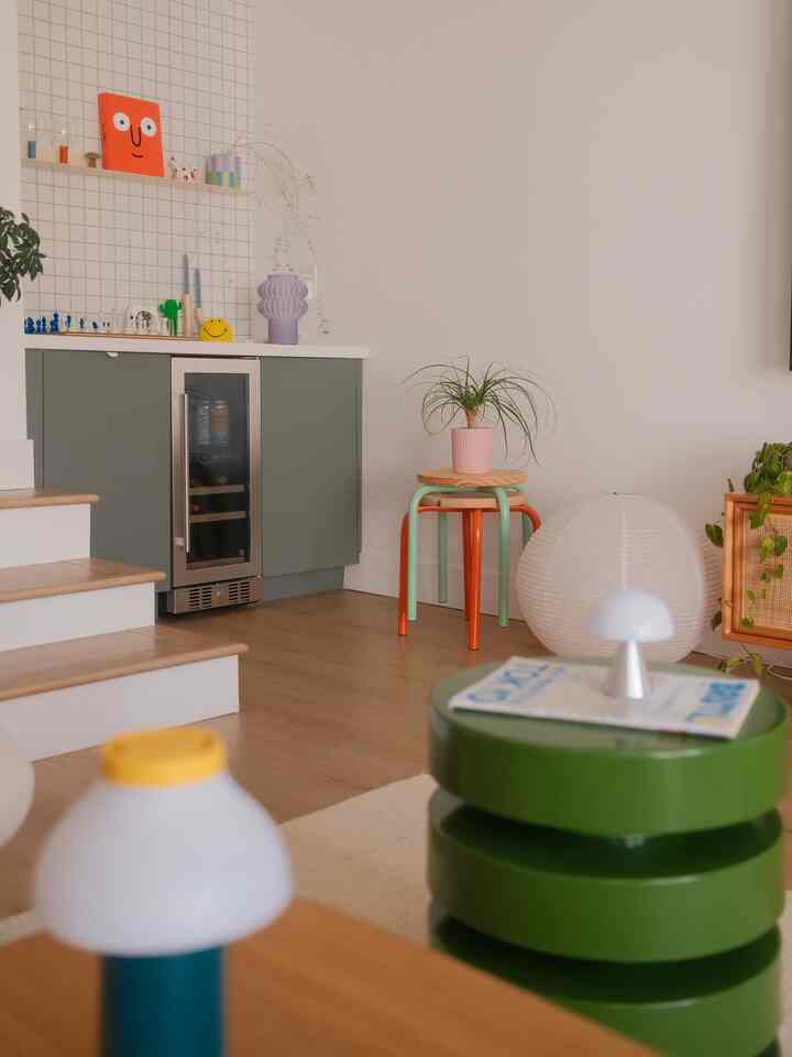 Natural-toned living room featuring green stools and white walls creating a cozy atmosphere
