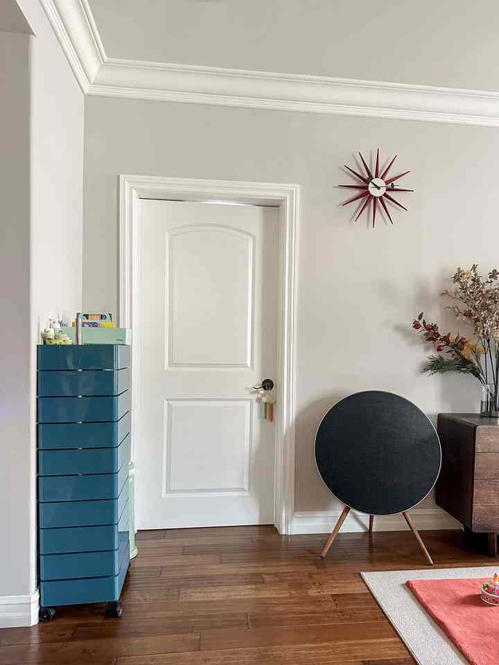 Modern living room interior with navy storage cart and Mid-Century Modern Nelson Sunburst clock on wall