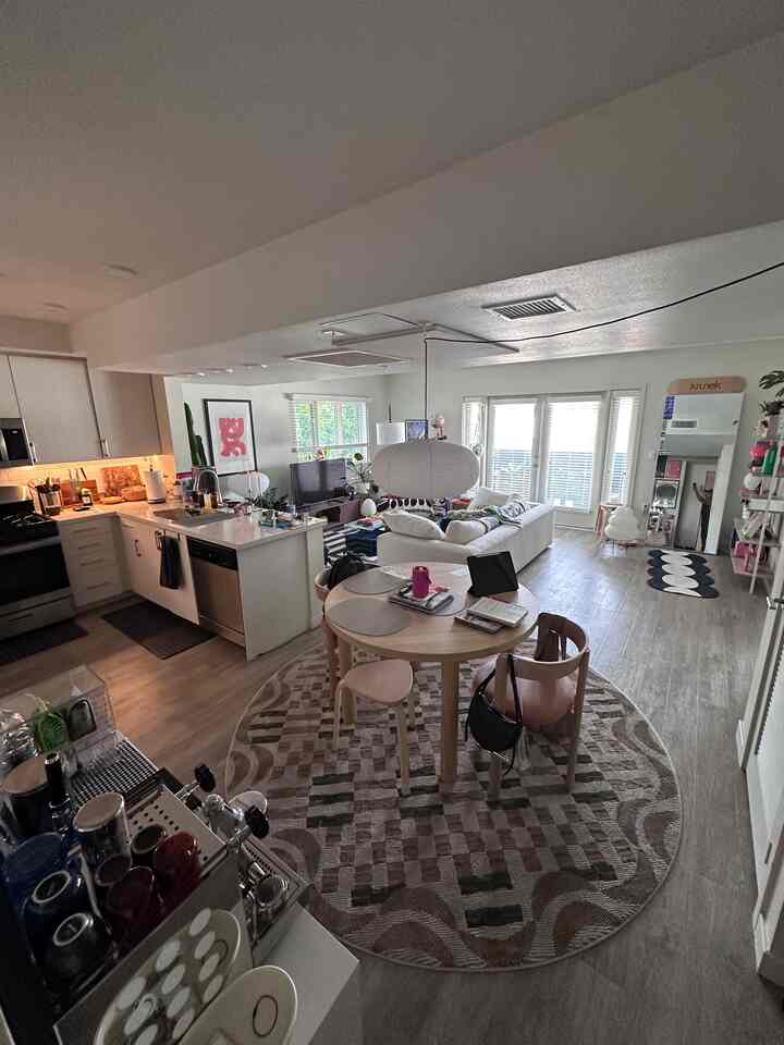 Natural and light brown toned dining room and living area featuring wooden dining set and sofa with a cozy, modern atmosphere