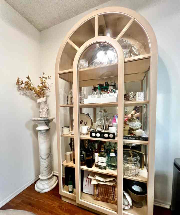 Warm wood tone cabinet with a marble pedestal in a cozy dining room space