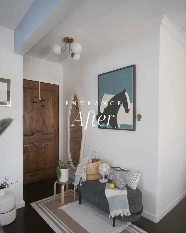 Natural color and wood tone entrance featuring a storage bench, large mirror, and wall art for a warm, functional space