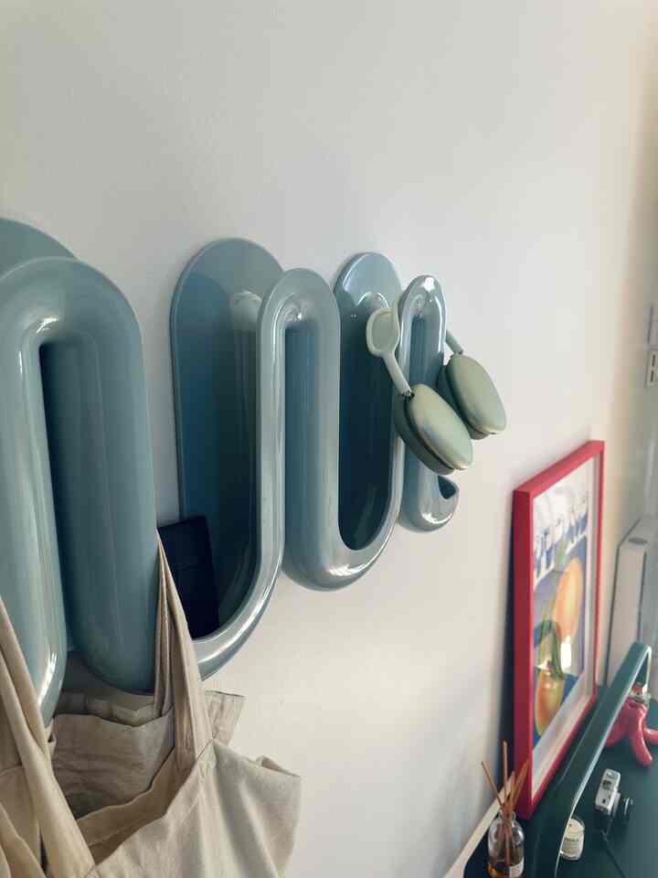Modern entrance with a pastel blue wave-shaped wall catchall mounted on white wall and a console table underneath, creating a tidy look