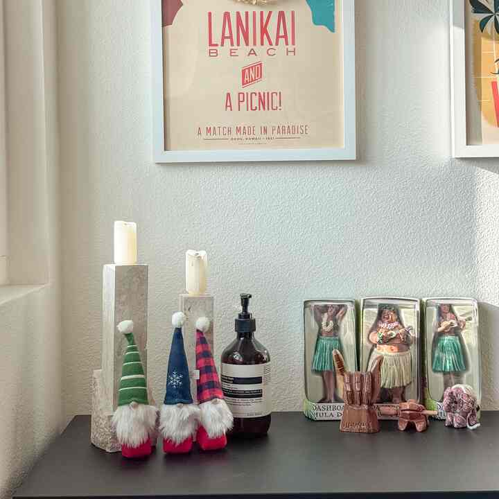 Cozy entrance vignette with natural wood tone table featuring Christmas figurines and stone candle holders