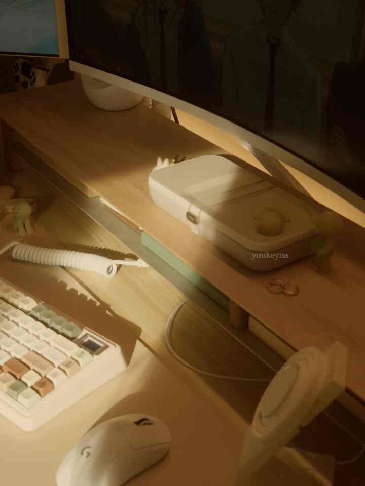 Cozy workspace featuring a warm wood tone and white home office desk with keyboard, mouse, and monitor stand