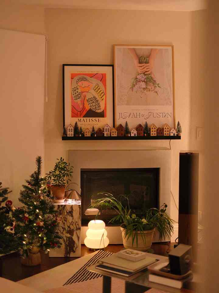 Warm brown and black toned living room featuring a fireplace, marble plinth with table lamp creating cozy ambiance