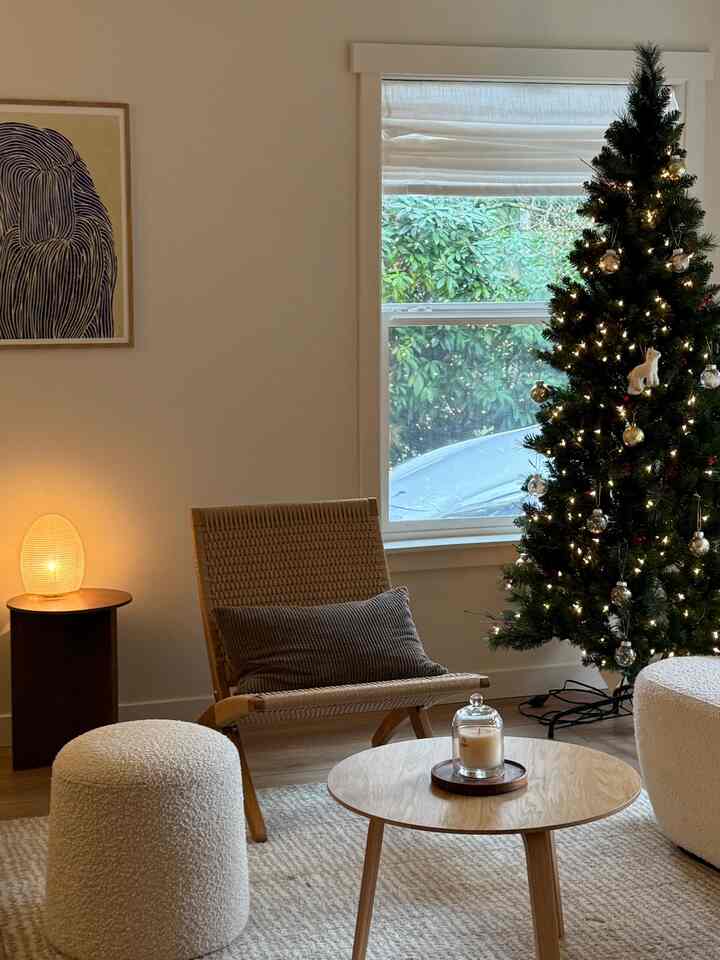 Warm-toned living room featuring Christmas tree, wooden coffee table, and an Art Deco-style armchair in a cozy setting